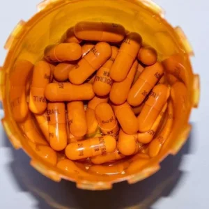 100 Adderall XR oral capsule in an open container, showcasing the distinct capsule design and clear labeling for easy identification.